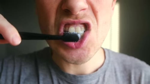 Close Up of a Man Brushing His Teeth with a Toothbrush