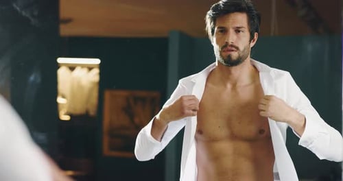 Attractive Man Buttons White Shirt Looking in Mirror