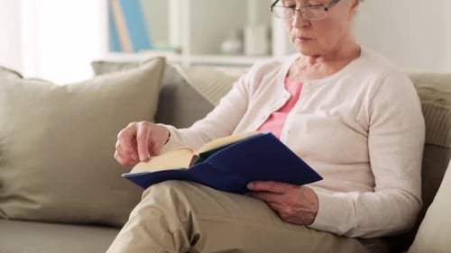 Age Leisure and People Concept - Senior Woman in Glasses Reading Book