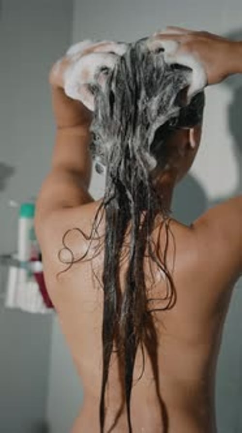 Young Woman Shampooing Her Hair in the Shower