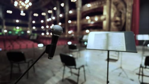 Microphone and Music Stand on Stage of Empty Concert Hall