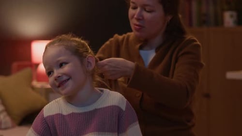 Woman Braiding Daughters Hair