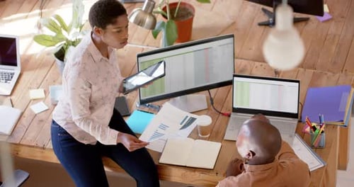 Des professionnels afro-américains discutent du travail dans un bureau