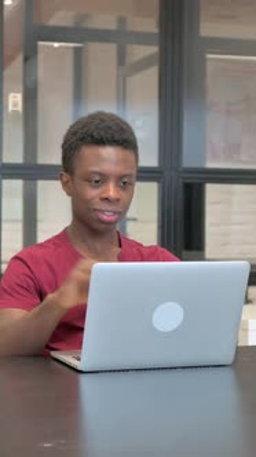 Young Adult Video Conferencing on Laptop in Office