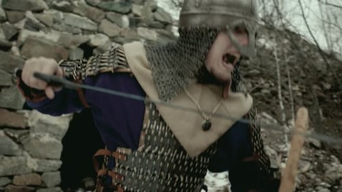 Medieval Man with Sword on Snowy Hillside