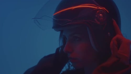 Woman Puts on Motorcycle Helmet in Neon Light