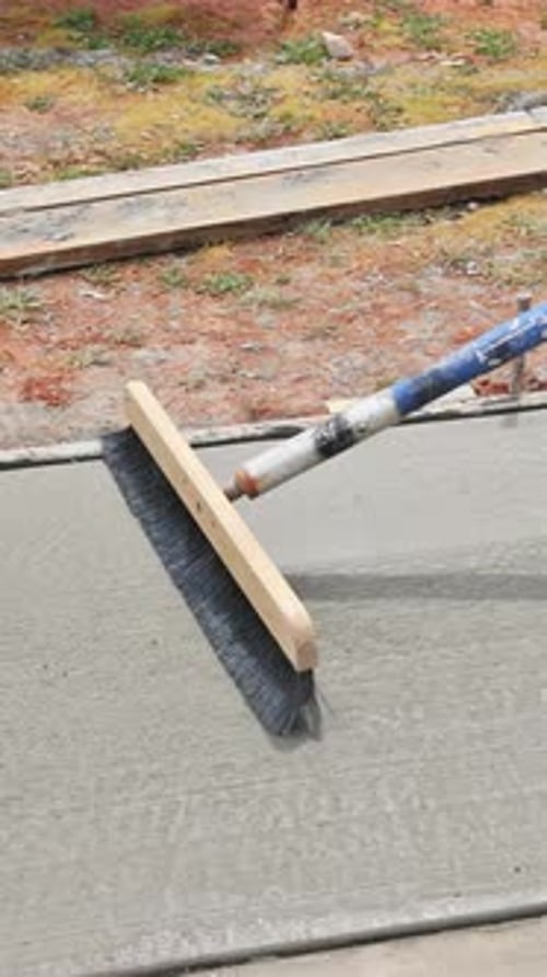 Concrete is Being Leveled at a Construction Site During Daylight Hours in a Residential Area