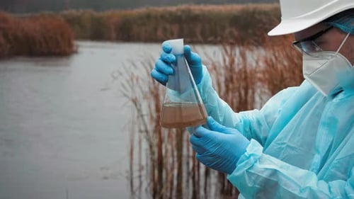 Young Scientist Biologist Analyzes Pollution Of Water And Soil Man With Flask For Expertise