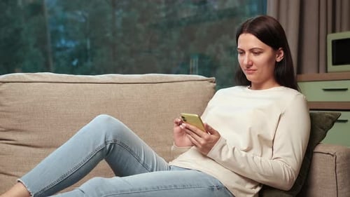 Woman Relaxing on Couch, Using Cell Phone