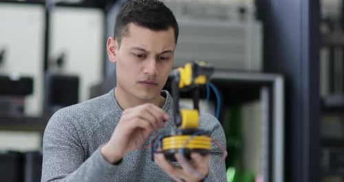 Junger Erwachsener arbeitet an Robotik