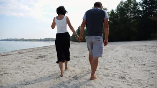 Couple Holding Hands of Each Other and Walking at Coast Happy Pair Going Along Seashore at Sunny Day