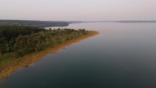 Aerial view of a peaceful lake and dense jungle at golden hour, untouched nature scene