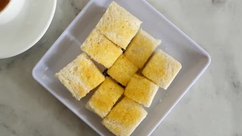 Top View of Butter Spared on a Bread on Tiles Background