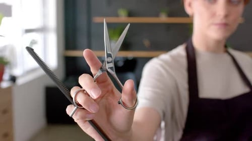 Woman Holding Scissors and Comb in Hair Salon