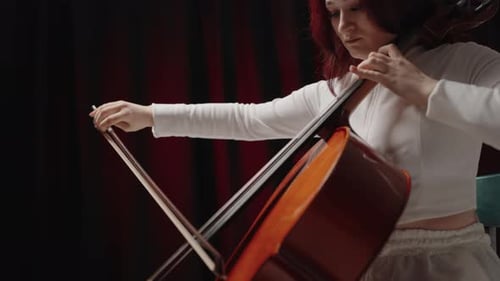 Young Adult Playing Cello in Music Room