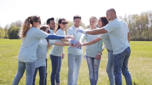 Diverse Team of Volunteers Puts Hands Together Outdoors
