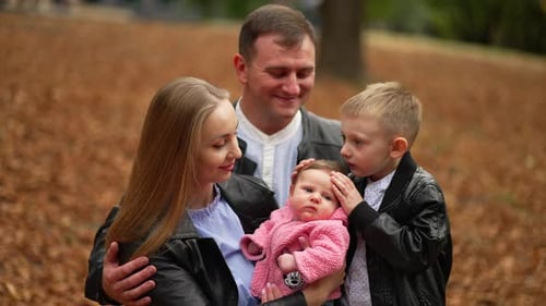 Loving Parents Enjoying an Autumn Day in the Park Happy Family Concept