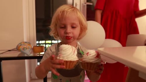 Blond Child Eats Cupcakes at Birthday Party
