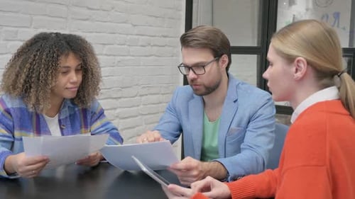Group of People Discussing Documents at Conference Table