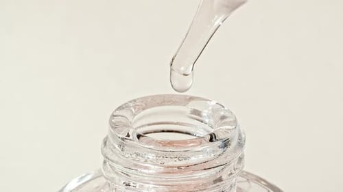 Liquid Dropping from Pipette into Bottle Close Up