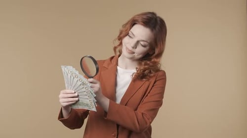 Woman Examining Money with Magnifying Glass