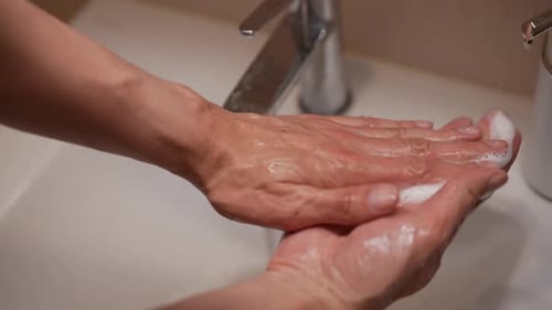 Firstperson View of Unrecognizable Man Soaping Hands in Bathroom with Modern Touchscreen Soap