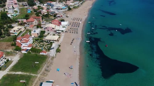 picturesque beach resort with turquoise waters, sandy shore, and coastal buildings.