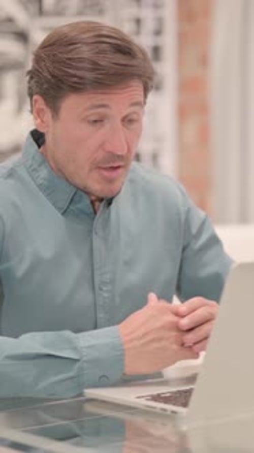 Man Video Conferencing on Laptop at Home