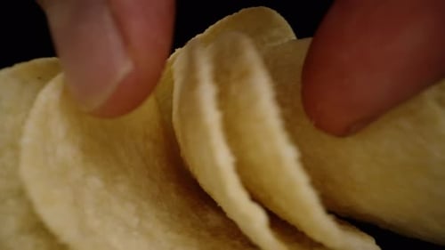 Saddle-shaped corn chips scattered on the table, and I pick them up one by one while the camera.