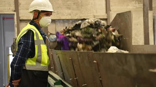 Recycling Plant Worker Overseeing Conveyor Belt