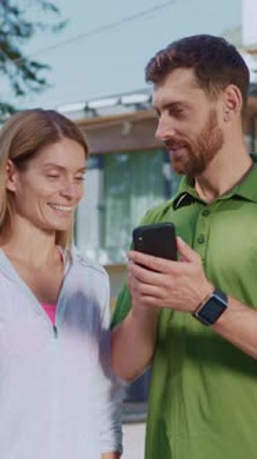 Couple Looking at Mobile Phone Outside