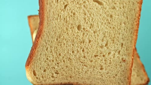 Pieces of Bread Fly Up and Fall on a Blue Background Filmed on a Highspeed Camera at 1000 Fps