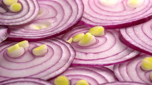 Sliced red onion rotates as background for cooking show, restaurant or food video. Sliced shallot