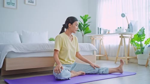 Woman Stretching on Yoga Mat in Bedroom