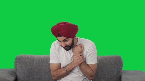 Sick Sikh Indian man suffering from hand pain Green screen