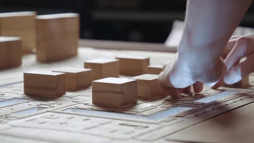 Hands of Professional Man Constructing Architecture Model of Urban City Building