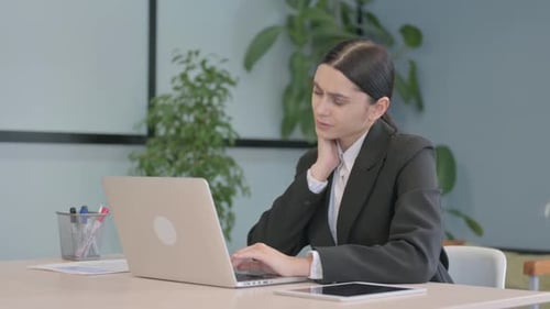 Woman Stretching Neck While Working on Laptop