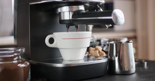 Home Espresso Making Process Coffee Stream Pouring From Machine Into Ceramic Cup