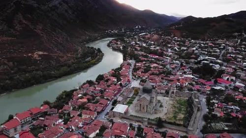 Tranquil Aerial Scenery of Georgian Town on the Shore of the River Near Mountain Range Filmed at