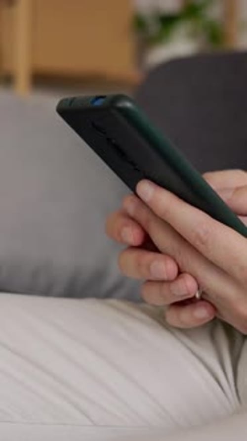 Hands Using a Phone on the Couch