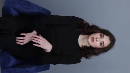 Glamorous Woman Posing Elegantly in Studio Chair