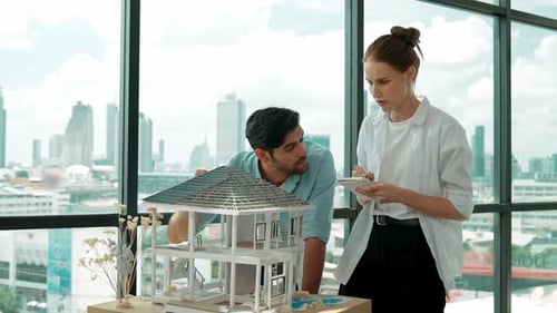 Architects Examining House Model in Modern Office