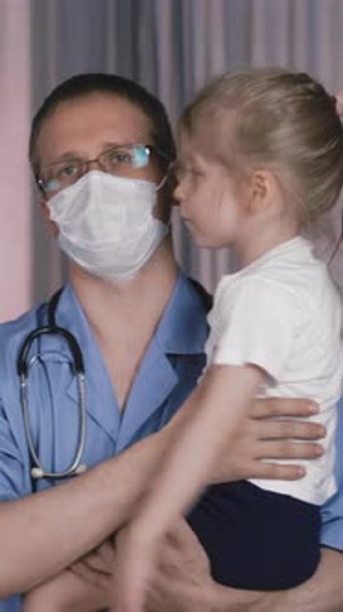 Medical Worker Holds Young Child in Hospital