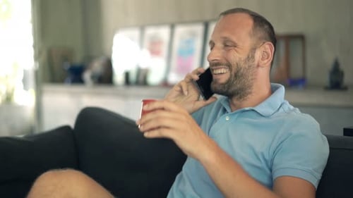 Relaxed Man Talking on Phone on Couch