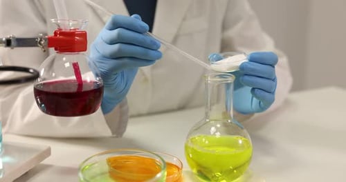 Scientist working with sample at white table in laboratory, closeup. Solution chemistry