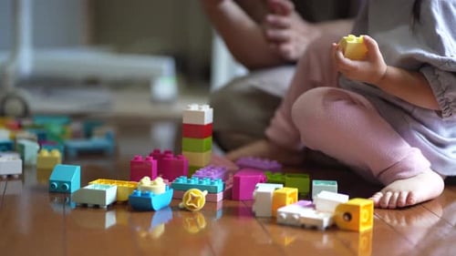 Child Playing with Colorful Building Blocks at Home