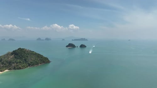 Speedboat Crossing Serene Blue Waters Surrounding Tropical Islands Under Clear Sky