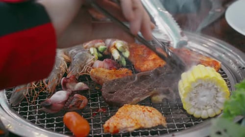 Sizzling Mix of Meat Seafood and Corn on Charcoal Grill