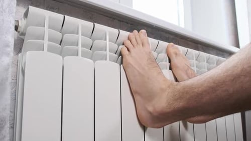 Feet Warming on a White Radiator Inside
