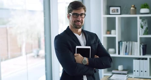 4k video footage of a handsome young businessman posing with his arms folded in his office
